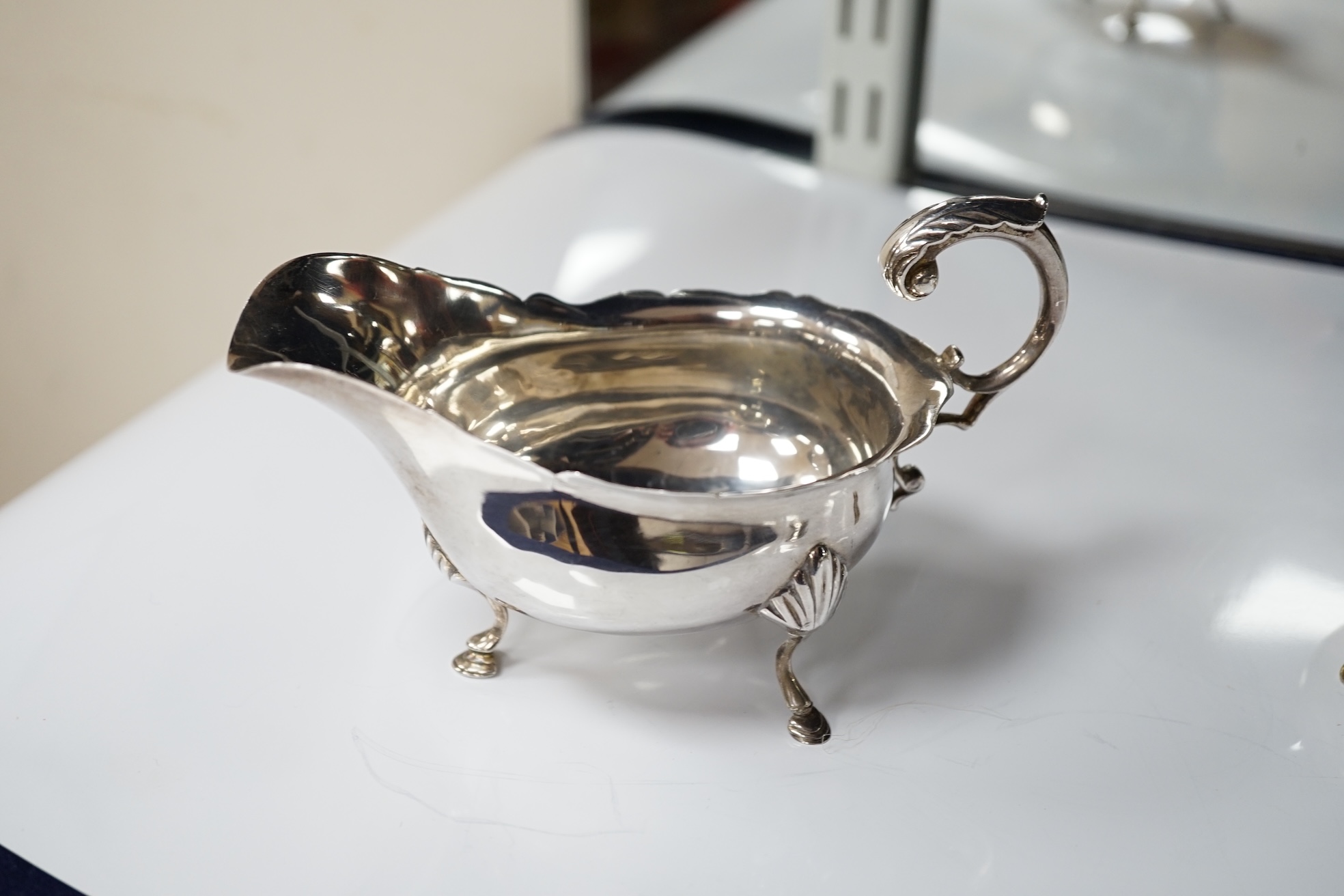 A pair of George III silver cauldron salts, London, 1765, with a pair of later Georgian mustard ladles, together with a late Victorian silver sauceboat. Condition - fair to good